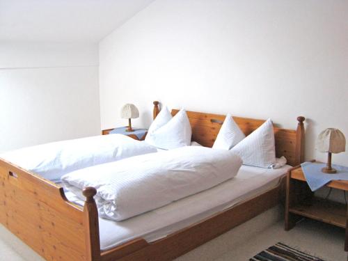een slaapkamer met een groot bed met witte lakens en kussens bij Gschwendtnerhof App17 Blum in Aschau im Chiemgau