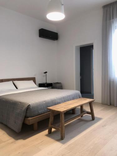 een slaapkamer met een bed en een houten tafel bij whiterooms in Cesena