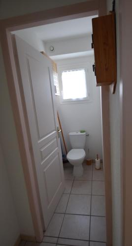 a bathroom with a toilet and a door with a window at T3 coquet et lumineux aux pieds des pistes in Ancelle