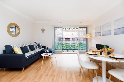 un salon avec un canapé bleu et une table dans l'établissement Home A YourHostHelper, à Cannes