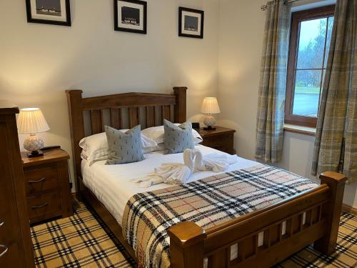 1 dormitorio con 1 cama con 2 mesitas de noche y una ventana en Tower Ridge Apartments, en Fort William