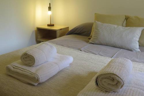 a bedroom with white towels on a bed at Main Street with a great Balcony in Ushuaia