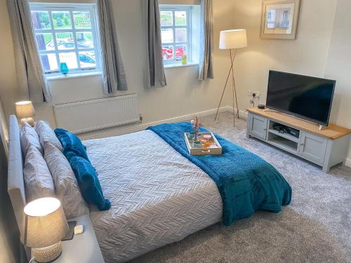 a bedroom with a large bed and a television at 4c Gaia Lane in Lichfield