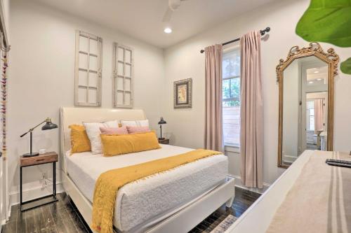 Schlafzimmer mit einem Bett mit gelben und rosa Kissen in der Unterkunft Historic 1900 Cottage in Downtown St Augustine! in St. Augustine