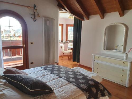 a bedroom with a bed with a dresser and a mirror at Villa Belmonte in Tresché Conca