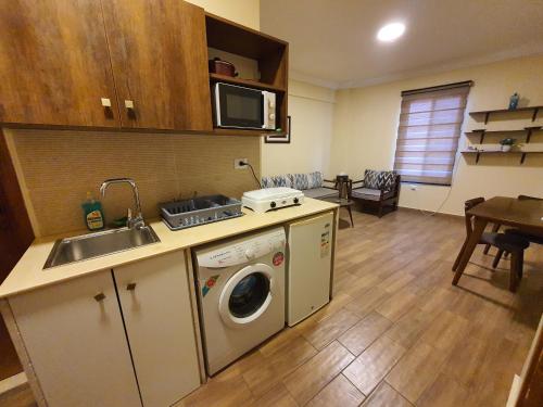a kitchen with a sink and a washing machine at Azur Suites Hotel & Apartments in El Mîna
