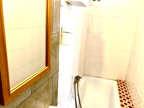 La salle de bains est pourvue d'une douche et d'une baignoire. dans l'établissement Sri-Indo Guest House, à Lisbonne