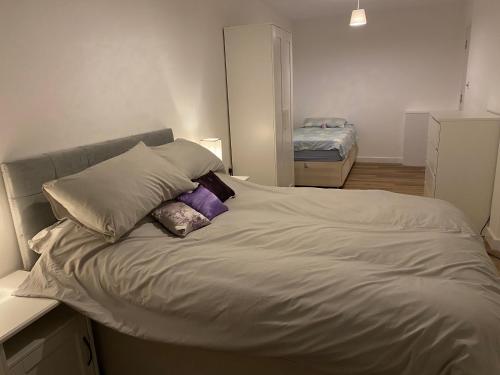 a bed with pillows on it in a bedroom at Adorable One-Bedroom Flat With Patio Garden. in Southwick