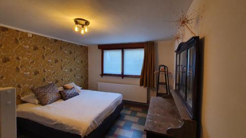 Una habitación de hotel con una cama y una ventana. en Villa Bella Rosa, en De Panne