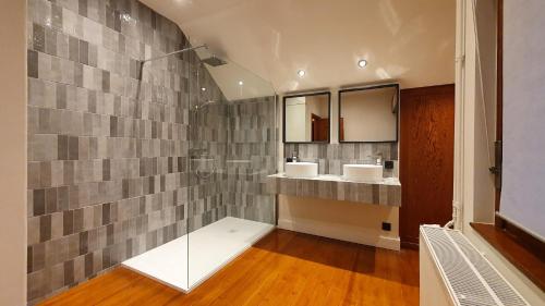 un baño con dos lavabos y dos espejos en Villa Bella Rosa, en De Panne