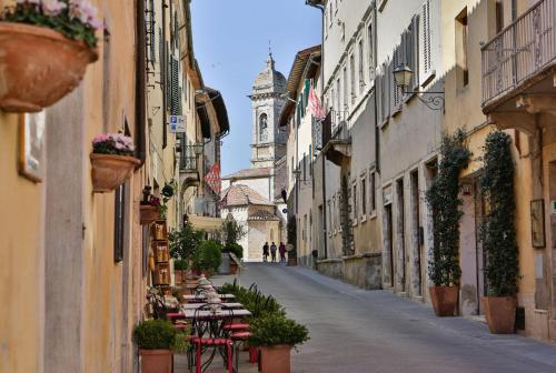 an empty street with tables and chairs in an alley at Camera La Margherita in San Quirico dʼOrcia