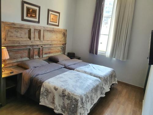 a bedroom with a bed and a wooden headboard at Azur Suites Hotel & Apartments in El Mîna