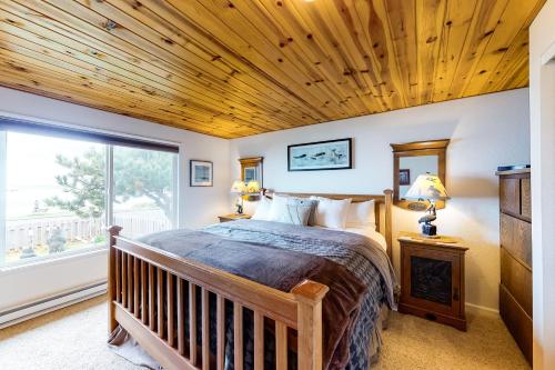 a bedroom with a bed with a wooden ceiling at Patty's Sea Perch in Yachats