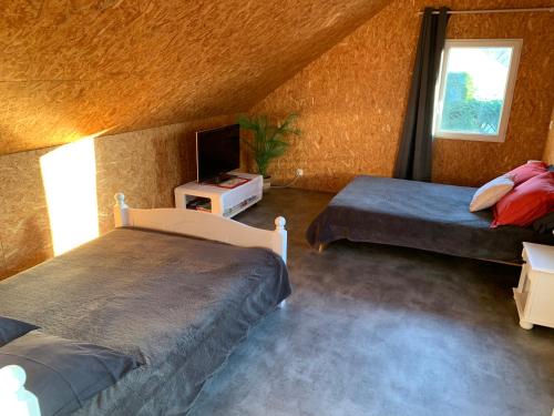 Un pat sau paturi într-o cameră la La maison du poulailler