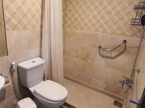 a bathroom with a toilet and a shower at Azur Suites Hotel & Apartments in El Mîna