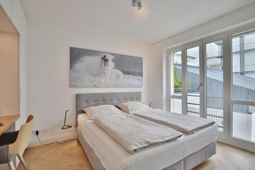 a bedroom with a bed and a desk and a window at Seaside Seaside Appartement 18 in Timmendorfer Strand