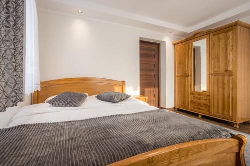 a bedroom with a wooden bed with two pillows at Leśny Dwór in Murzasichle