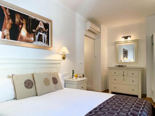 a bedroom with a white bed and a painting on the wall at CASA GALA BIAR. TRANQUILIDAD, ENCANTO Y AIRE PURO. in Biar