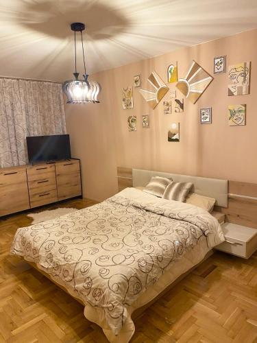 a bedroom with a bed and a flat screen tv at Spacious Apartment next to South Park Просторен Апартамент до Южен Парк Top Location in Sofia