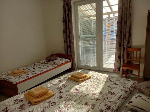 two twin beds in a room with a window at Alegria Natur Apartments in Mikulov