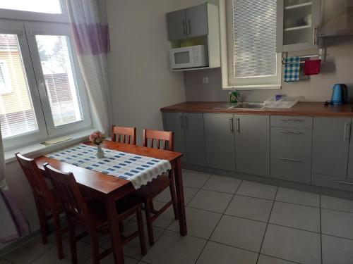a kitchen with a wooden table and chairs and a table and chairsktop at Alegria Natur Apartments in Mikulov