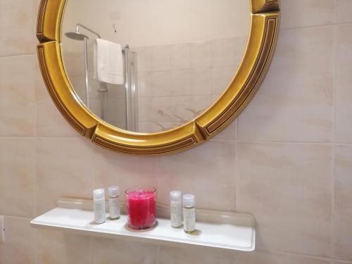 a bathroom with a mirror and a candle on a shelf at Locanda Dell'Oleificio in Mezzane di Sotto