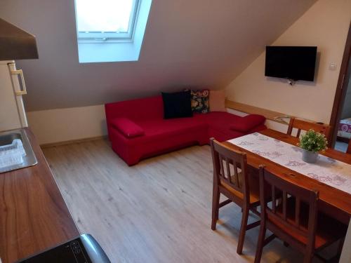 a living room with a red couch and a table at Alegria Natur Apartments in Mikulov