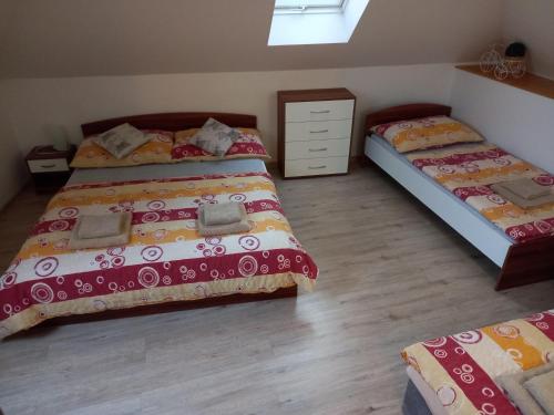 a bedroom with two beds and a dresser at Alegria Natur Apartments in Mikulov
