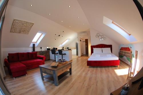 a living room with a bed and a red couch at Apartament Książęcy klimatyzacja in Żagań