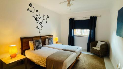 a bedroom with a bed and a fan and a window at Bicos 101 by Check-in Portugal in Albufeira