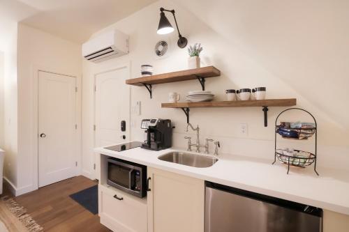 a kitchen with a sink and a microwave at New Tudor Cottage one block from Chico State and downtown with private garage in Chico