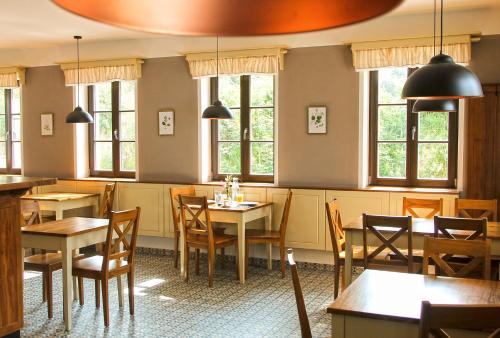 a restaurant with tables and chairs and windows at Dvůr Lískový vrch in Strážný