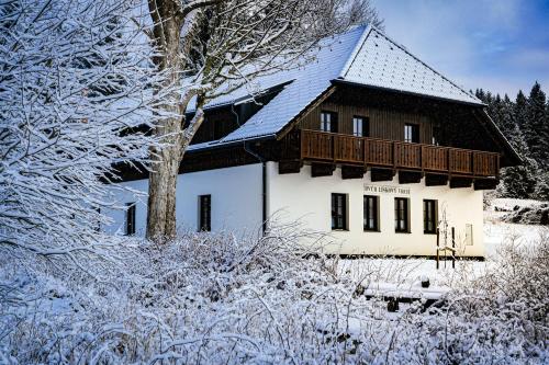 a house covered in snow in front at Dvůr Lískový vrch in Strážný