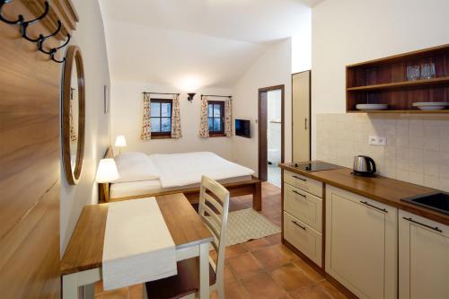 a kitchen with a table and a bed in a room at Dvůr Lískový vrch in Strážný