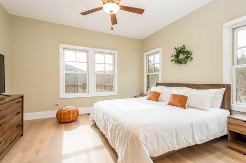een slaapkamer met een bed, een plafondventilator en ramen bij Cullowhee Home with Game Room, Wraparound Decks in Cullowhee