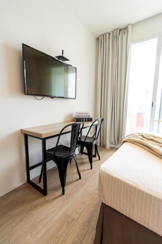 a bedroom with a desk with two chairs and a bed at 360 Suítes Sé in Sao Paulo
