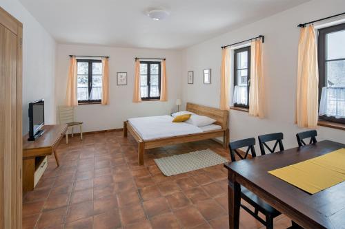a room with a bed and a table and chairs at Dvůr Lískový vrch in Strážný