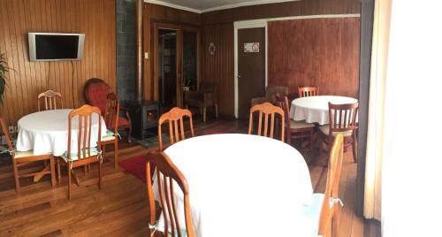 a woman sitting at a table in a room with two tables at Hostal Argentina Osorno in Osorno
