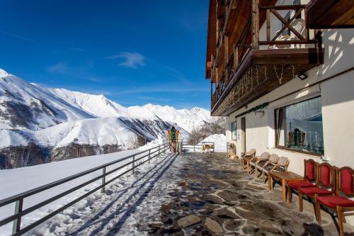 d'un balcon avec des chaises et une vue sur les montagnes enneigées. dans l'établissement Veranda Hotel, à Goudaouri