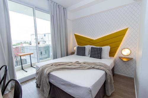 a bedroom with a bed with a yellow headboard at 360 Suítes Sé in Sao Paulo