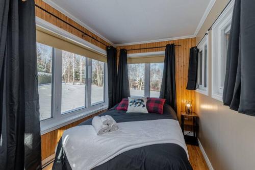 En eller flere senge i et værelse på Spa, sauna et foyer : Le Phare de Baie-Saint-Paul