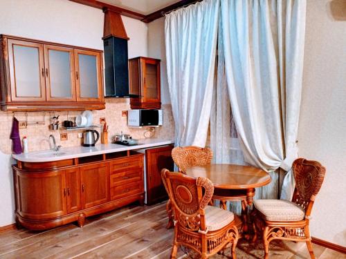 a kitchen with a table and chairs and a sink at Апартаменты в двух шагах от метро in Kharkiv