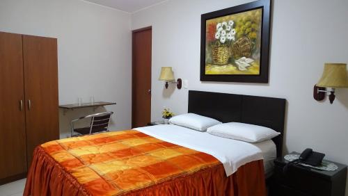 Hospedaje Dimar Inn في ليما: غرفة نوم بسرير ودهان على الحائط
