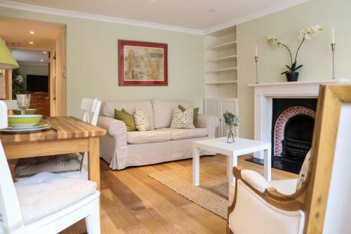 a living room with a couch and a fireplace at Stunning Chelsea Nest in London
