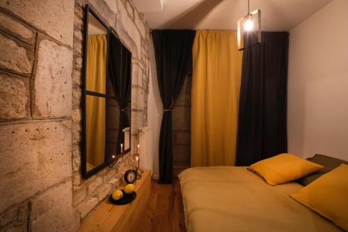 a bedroom with a bed and a brick wall at Appartement avec sauna au pied de la citadelle in Besançon
