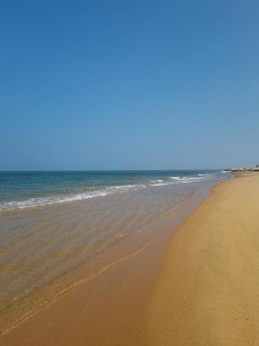 an empty beach with the ocean in the background at Wellé Wadiya Beach Villa in Kalpitiya
