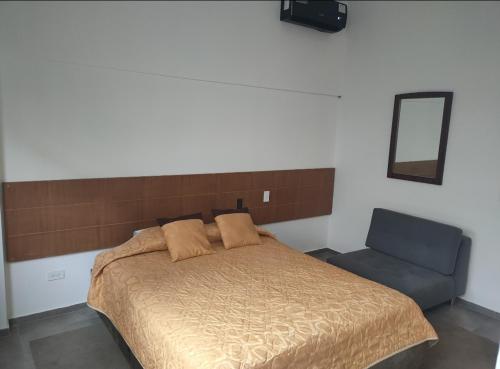 a bedroom with a bed and a mirror and a chair at HOTEL BOUTIQUE PANAMÁ in Guayaquil