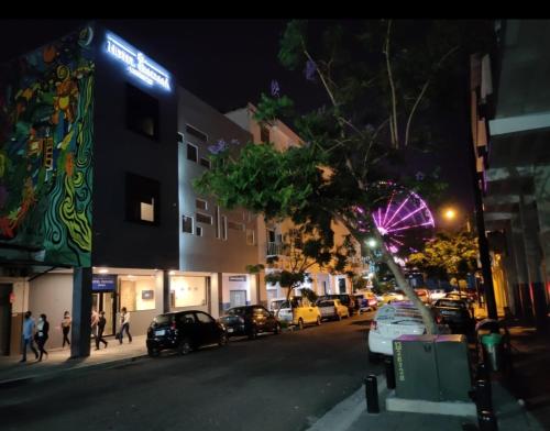 Una calle de la ciudad por la noche con coches aparcados en la calle en HOTEL BOUTIQUE PANAMÁ, en Guayaquil