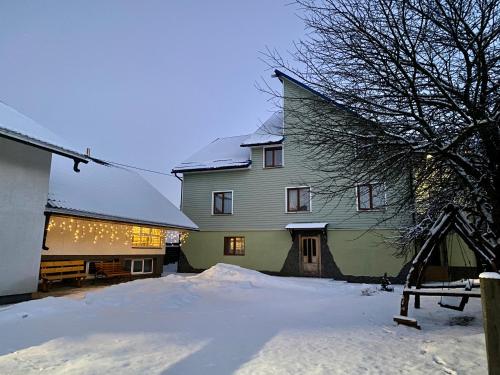 uma casa grande com neve em frente em Medova Hata em Verkhnyaya Rozhanka