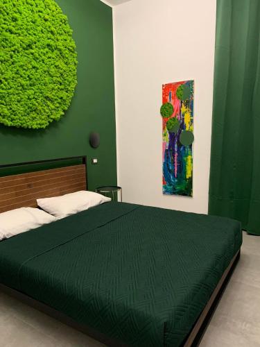 ein Schlafzimmer mit einem Bett mit einer grünen Wand in der Unterkunft B&B SOUL Messina in Messina